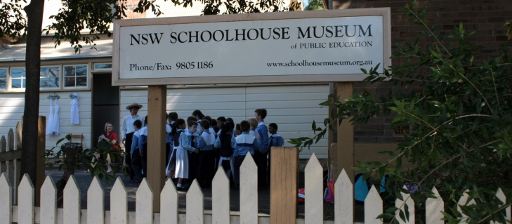 A visiting class lines up outside the Schoolhouse Museum 