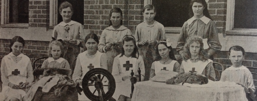 Students with spinning while and knitted items for soldiers 1917