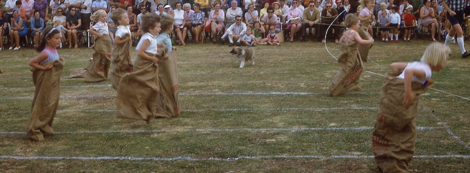 School sports carnival 1960's . Students are inside sacks and jumping.